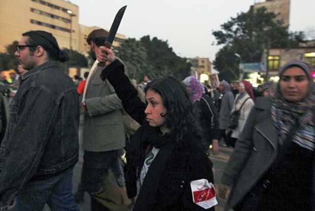 یک بانوی معترض چاقو در دست داشت و شعارهایی می داد برعلیه رئیس جمهور مصر، محمد مرسی و اعضای اخوان المسلمین به دلیل آزار و اذیت جنسی و خشونت علیه زنان در قاهره (رویترز)