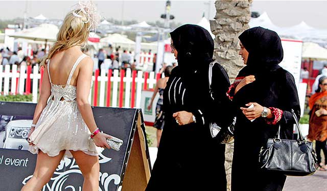 دو خانم مسلمان محافظه کار با پوشش اسلامی در برابر خانمی با آخرین مد غربی