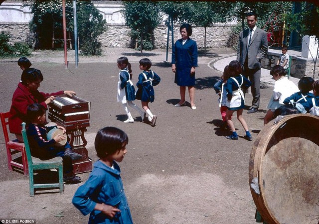 در این تصویر دانش آموزان با یونیفورم آبی رنگ دیده می شوند که با موزیک به پایکوبی و دست افشانی می پردازند.